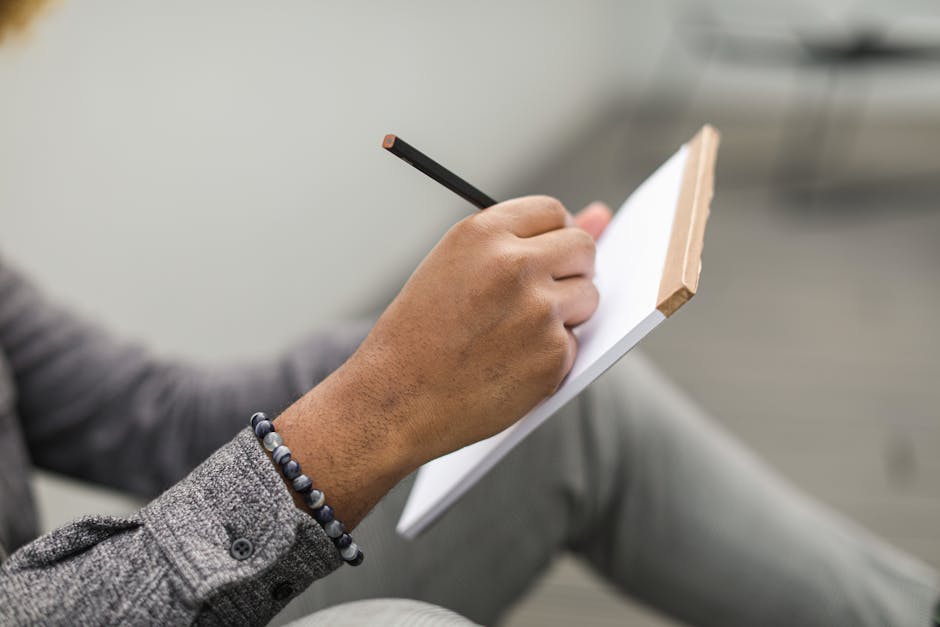 Engineer writing step-by-step security threat scenarios for an API on paper.