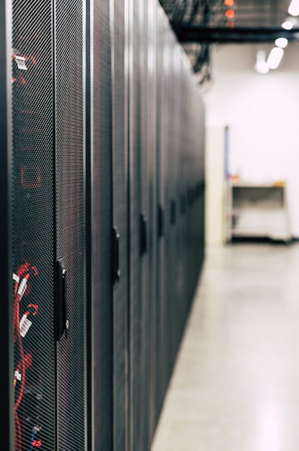 Technician in a server room reviewing backup drives and monitoring systems
