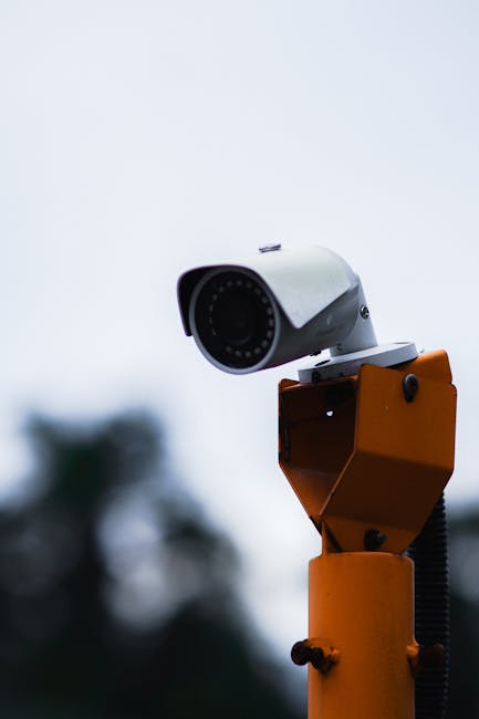 Security camera mounted on a construction site overlooking gate and equipment area