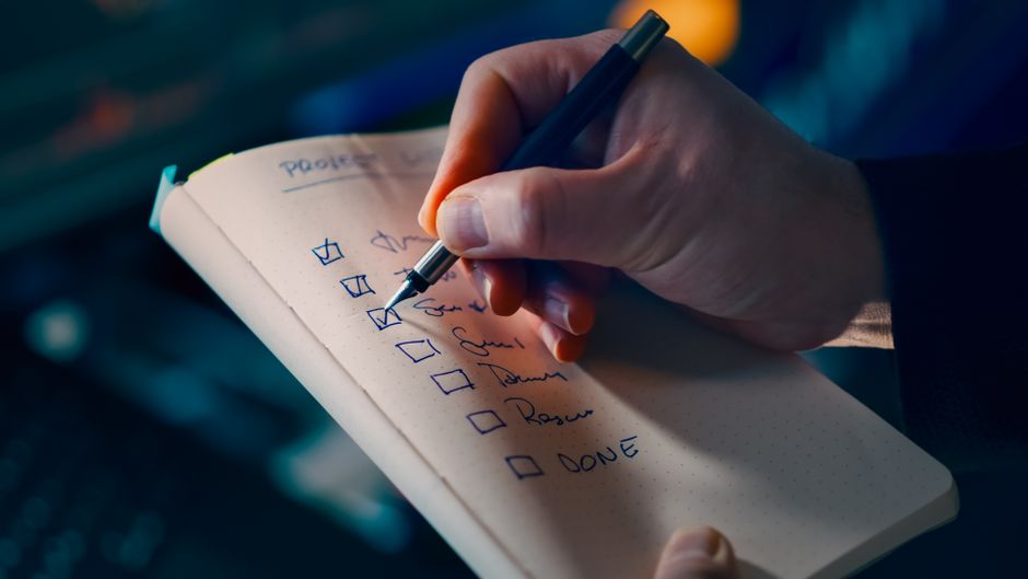 Close-up of hands checking items on a checklist on a laptop, representing app evaluation steps